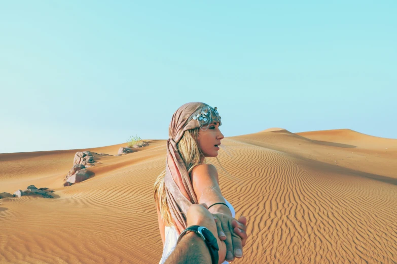 a young person in an indian head wrap, standing in the desert