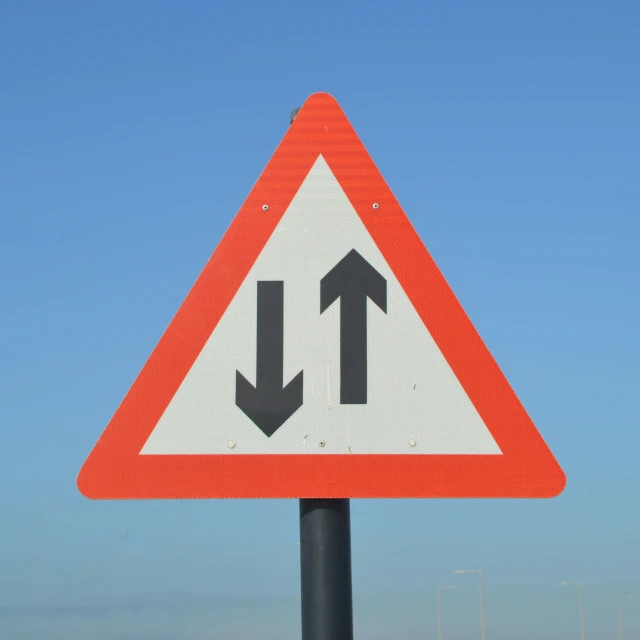 a warning sign indicating people are turning the left lane