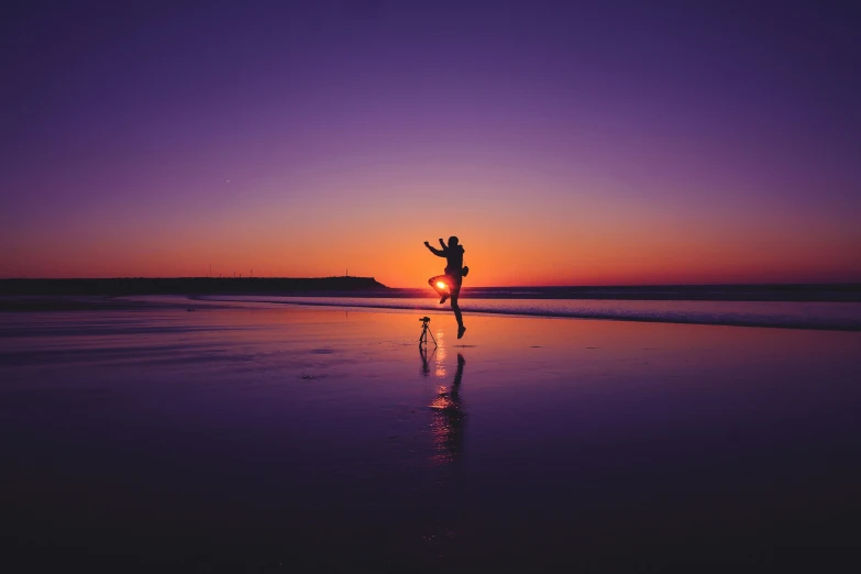 man on the beach during sunset with arms outstretched