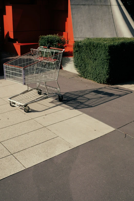 an empty shopping cart is sitting on the sidewalk