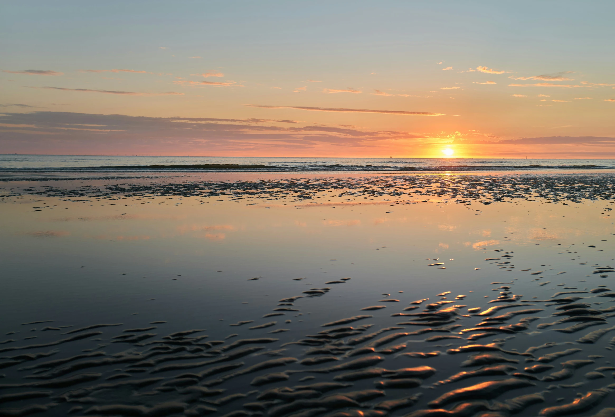 some sand water and the sun is rising