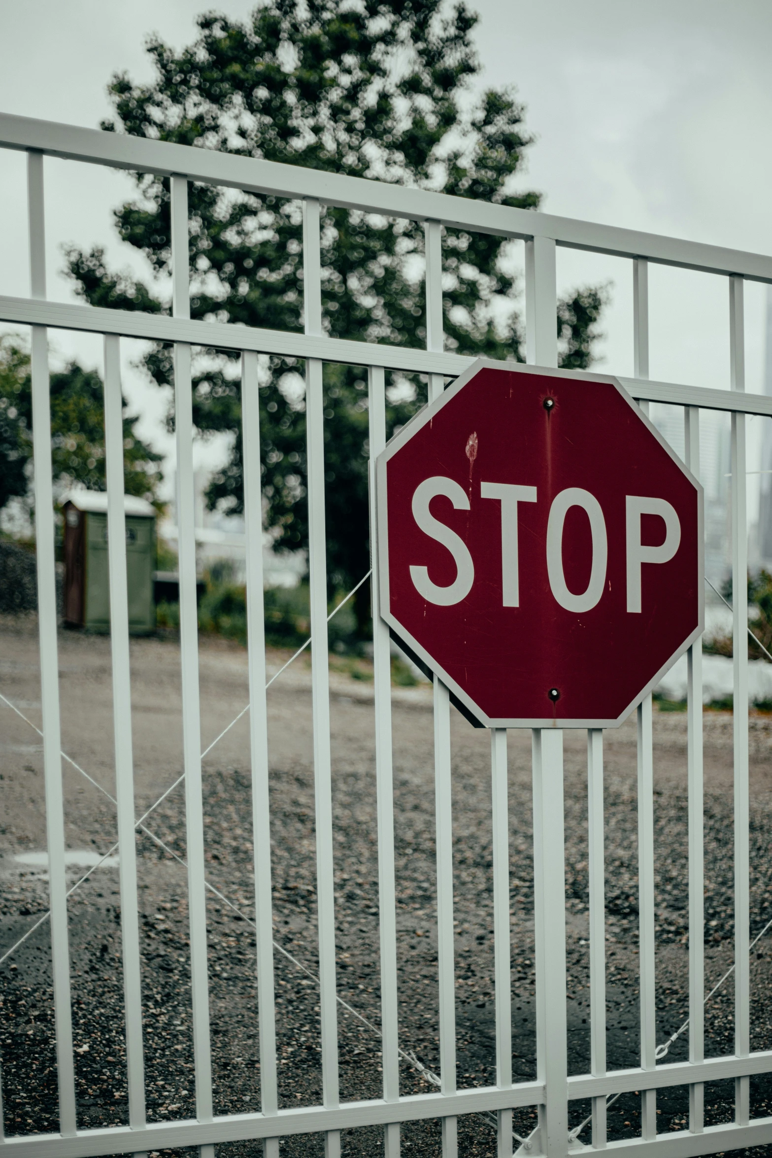 a stop sign over an iron fence on a street