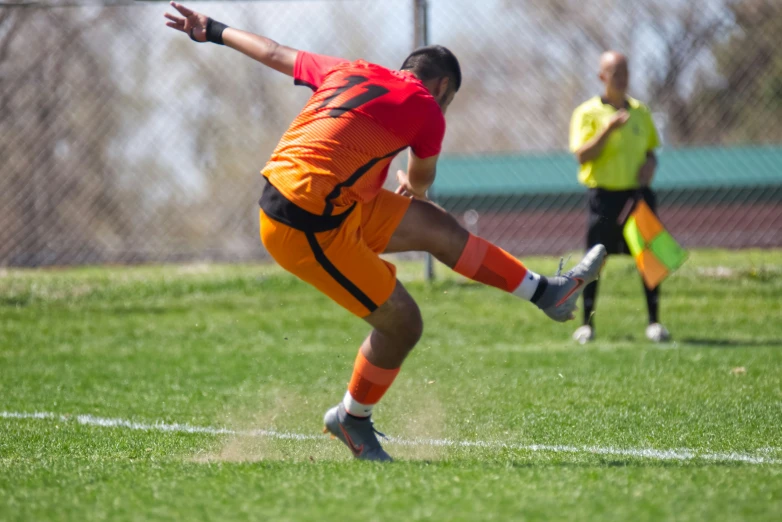 a soccer player running to kick a ball in a field