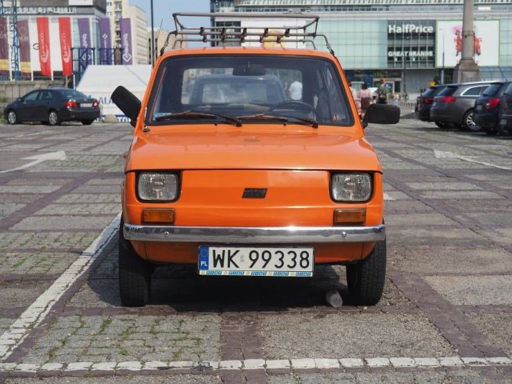 an orange vehicle parked on a paved road