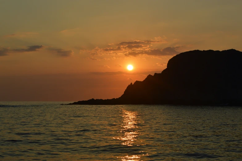 the sun setting over the ocean as it reflects in the water