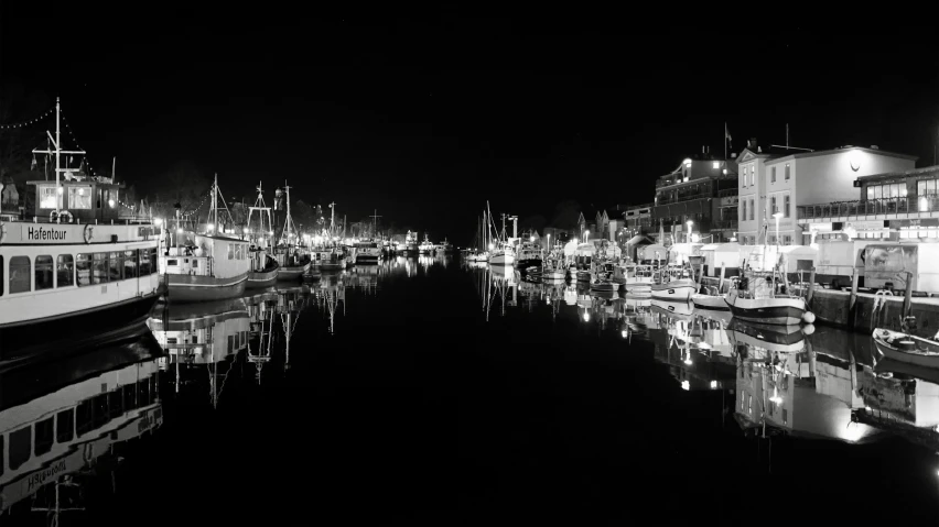 black and white po of a dock area with several boats docked