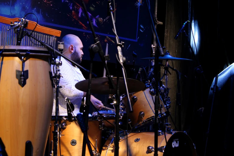 the man is playing drums on stage in front of his band