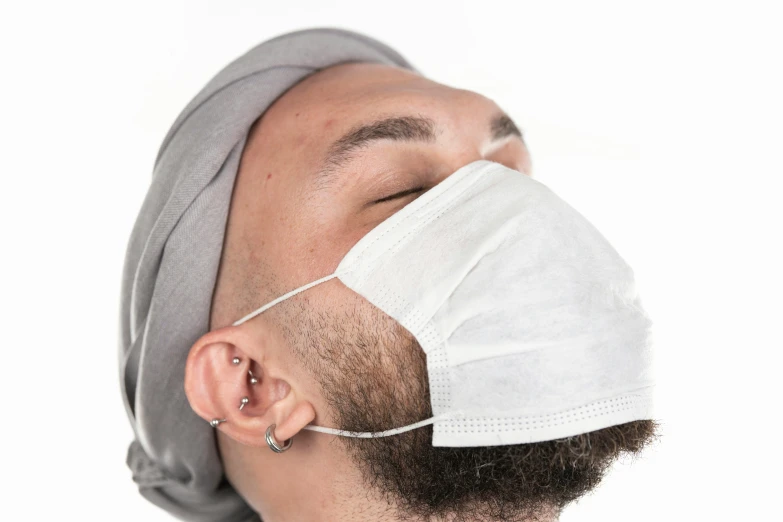 a person wearing a white surgical mask while looking down