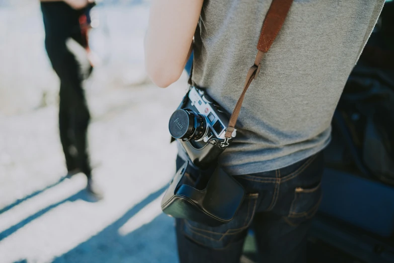 a man is holding his camera while another man is taking a picture