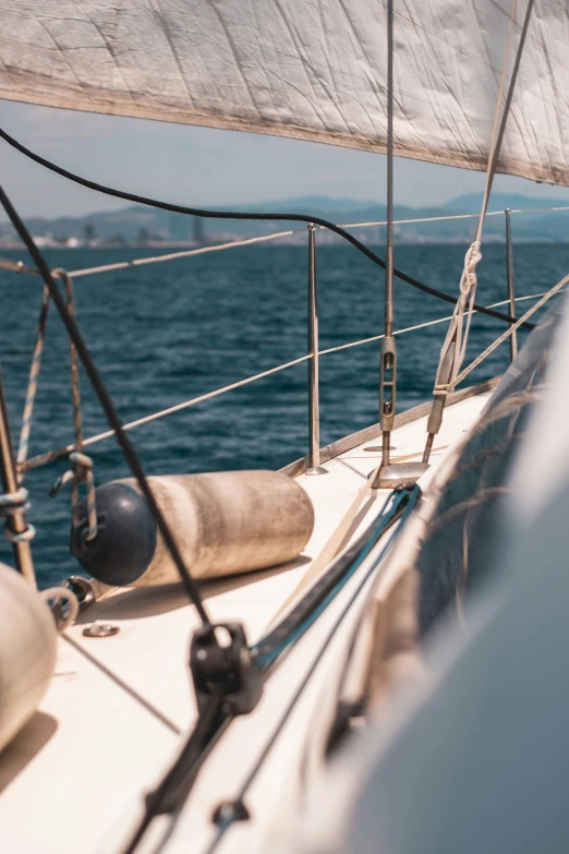 a sailboat with white sails on the ocean