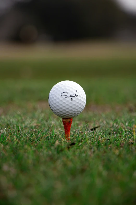 a golf ball sitting on top of a tee on a green grass covered golf course