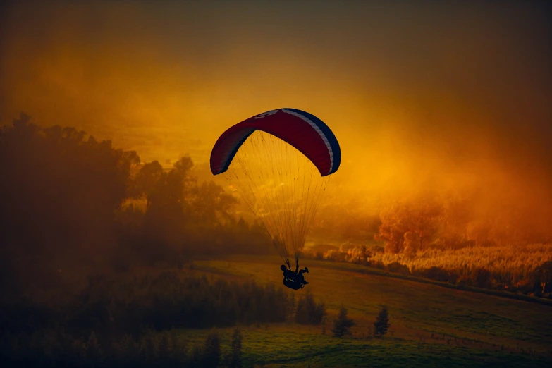 a person on the parachute flying through the air