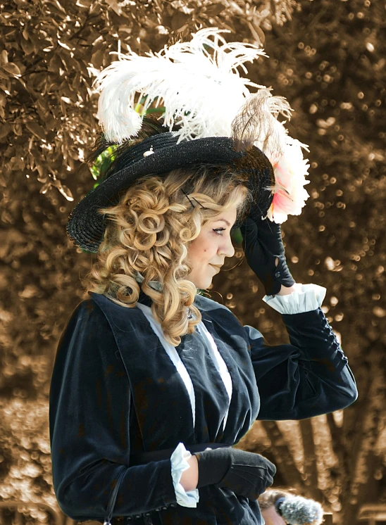 a woman wearing black with a hat and feathered dress