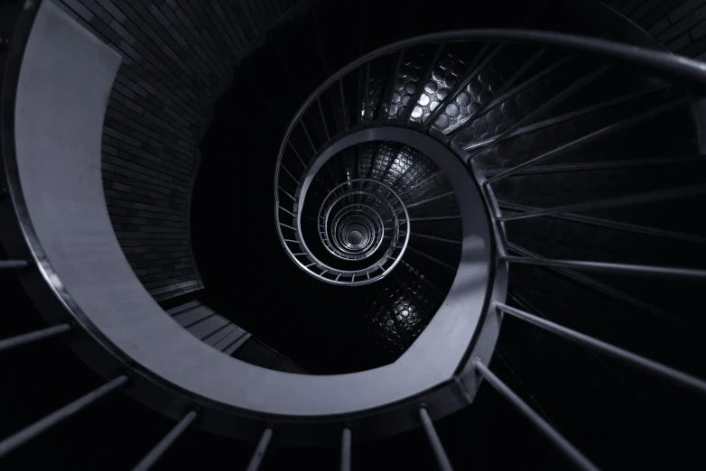 looking down at a spiral staircase in the dark