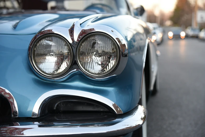 a vintage blue car is parked on a street