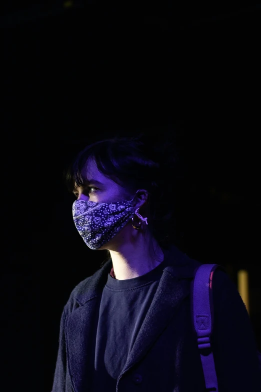 a person with a cloth face mask at night