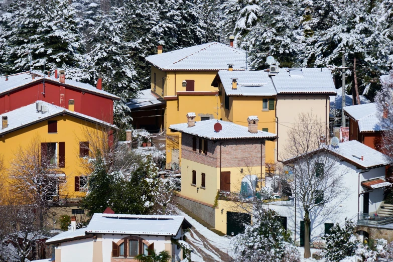 small buildings with red and yellow on a snow covered hill