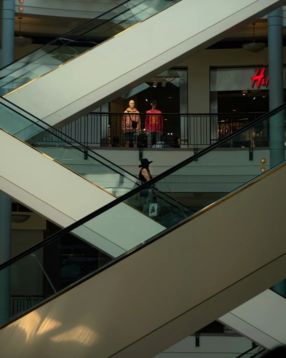 the person is going down the escalator outside of the building