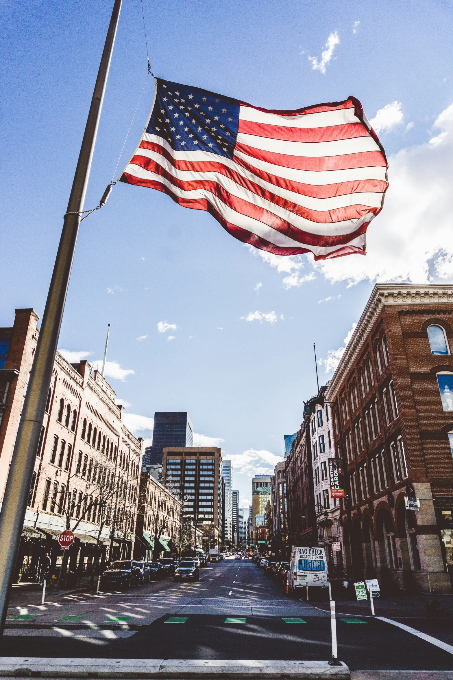 an american flag on top of the city street