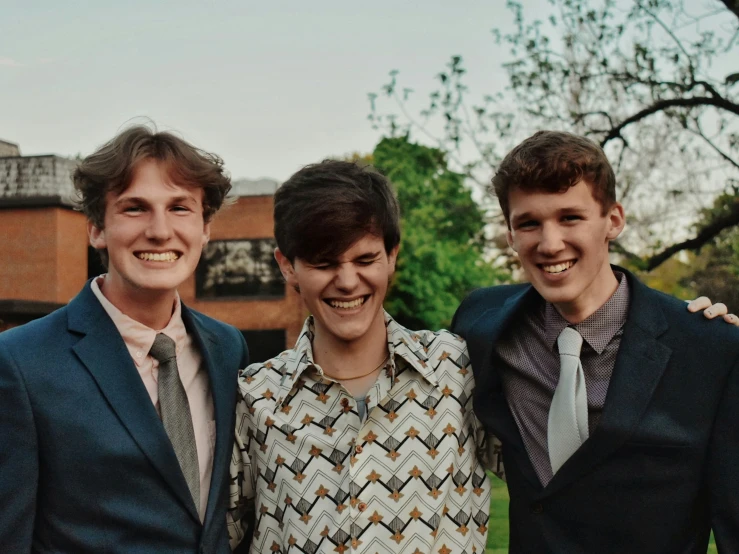 three men pose for a pograph while dressed in suits