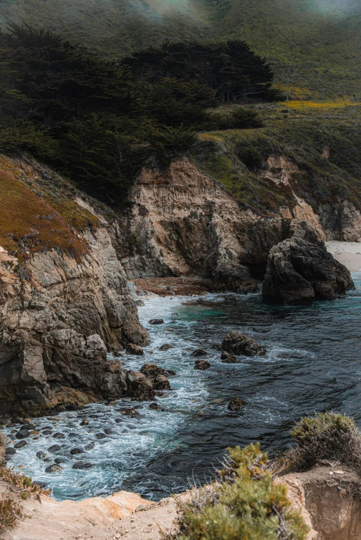 an umbrella sits on the edge of an open cliff overlooking the beach