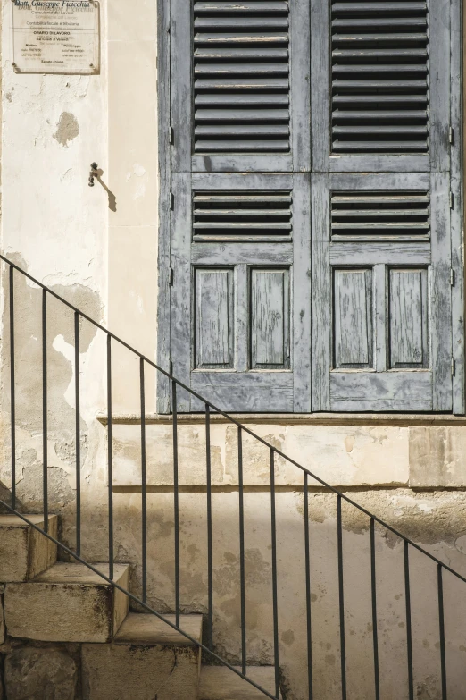 an open staircase with blue shutters and a fire hydrant