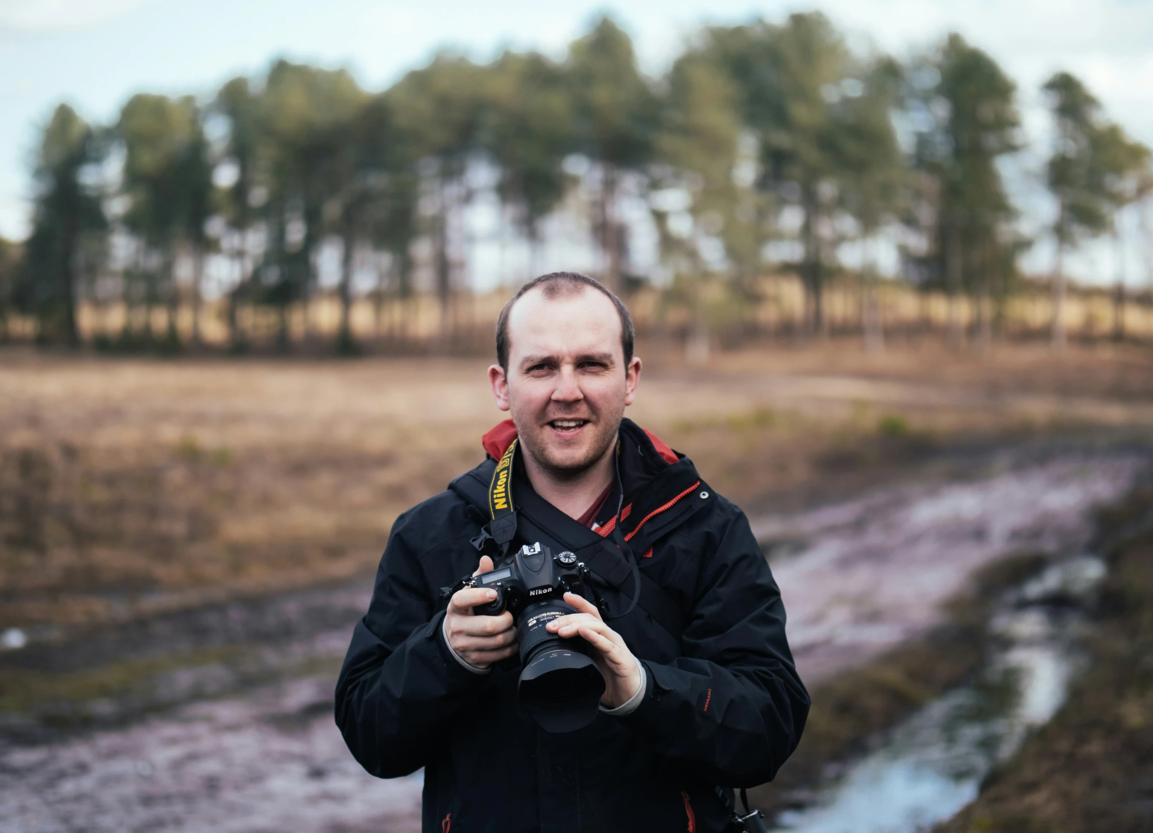 a man that is taking a picture in the grass