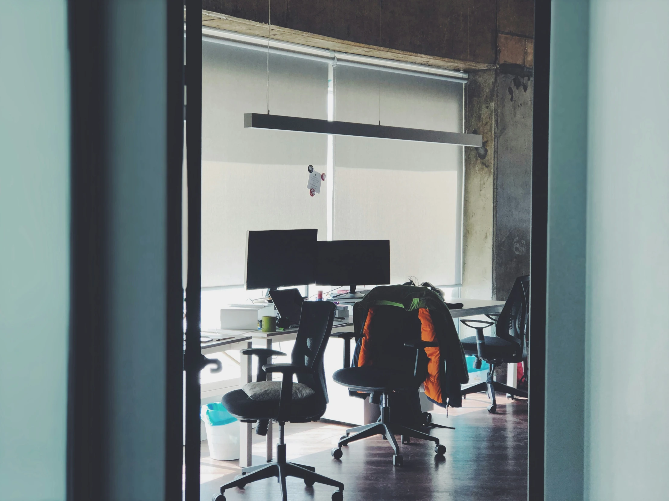 an office space with a chair, computer, keyboard and guitar