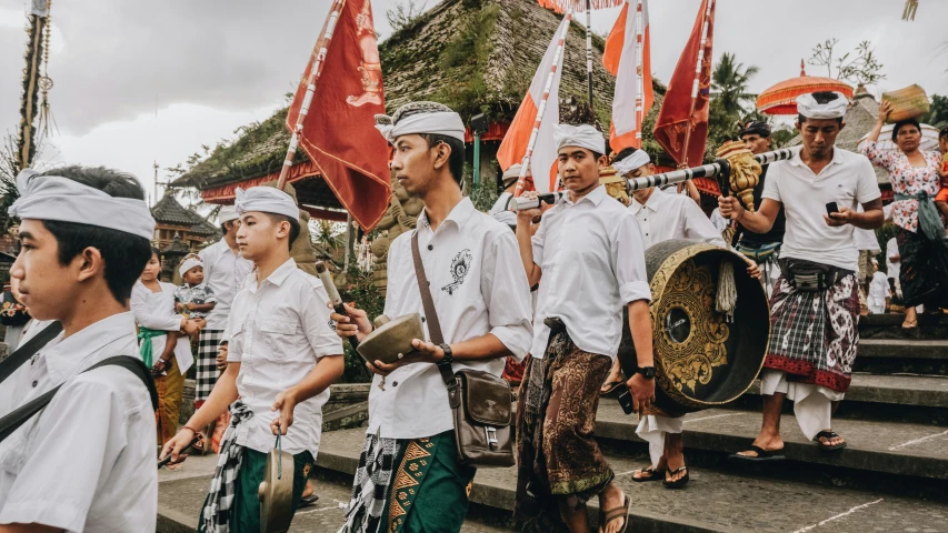 s in traditional thai garb carrying drums and flags