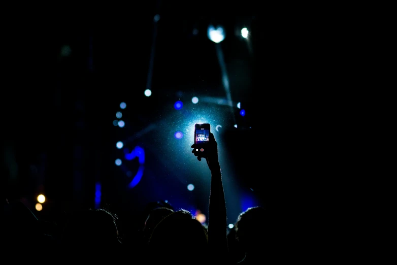 someone holding their phone up at the stage