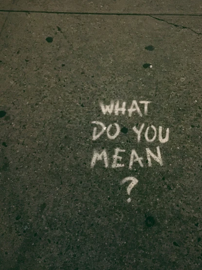 graffiti writing on asphalt with a person's handwritten message below it
