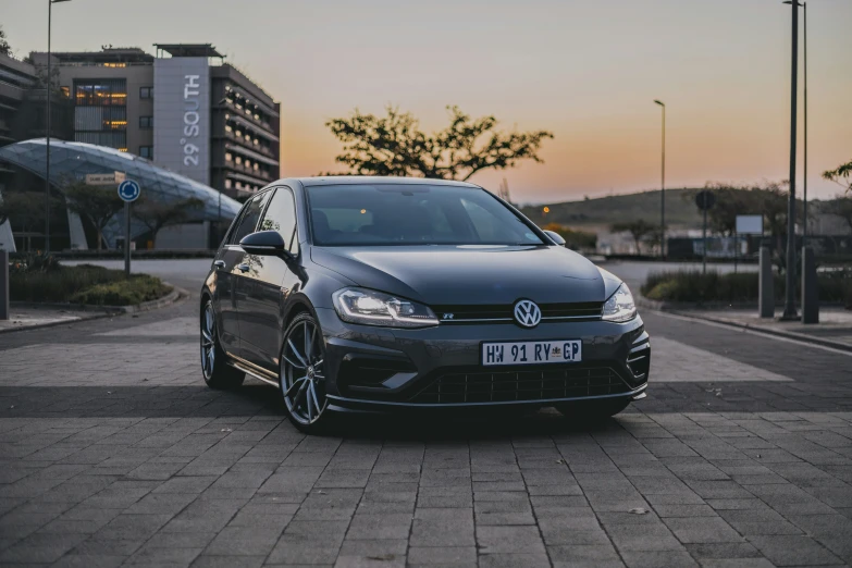 a black car is parked near the tall building