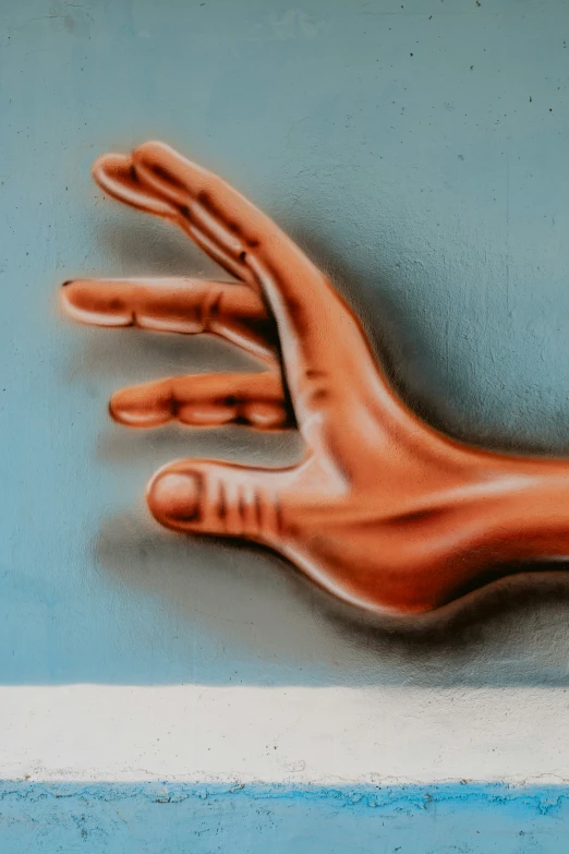 painting of a hand with brown painted nails against a blue background