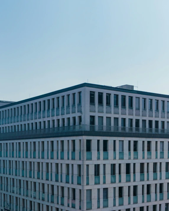 a tall white building with balconies next to it