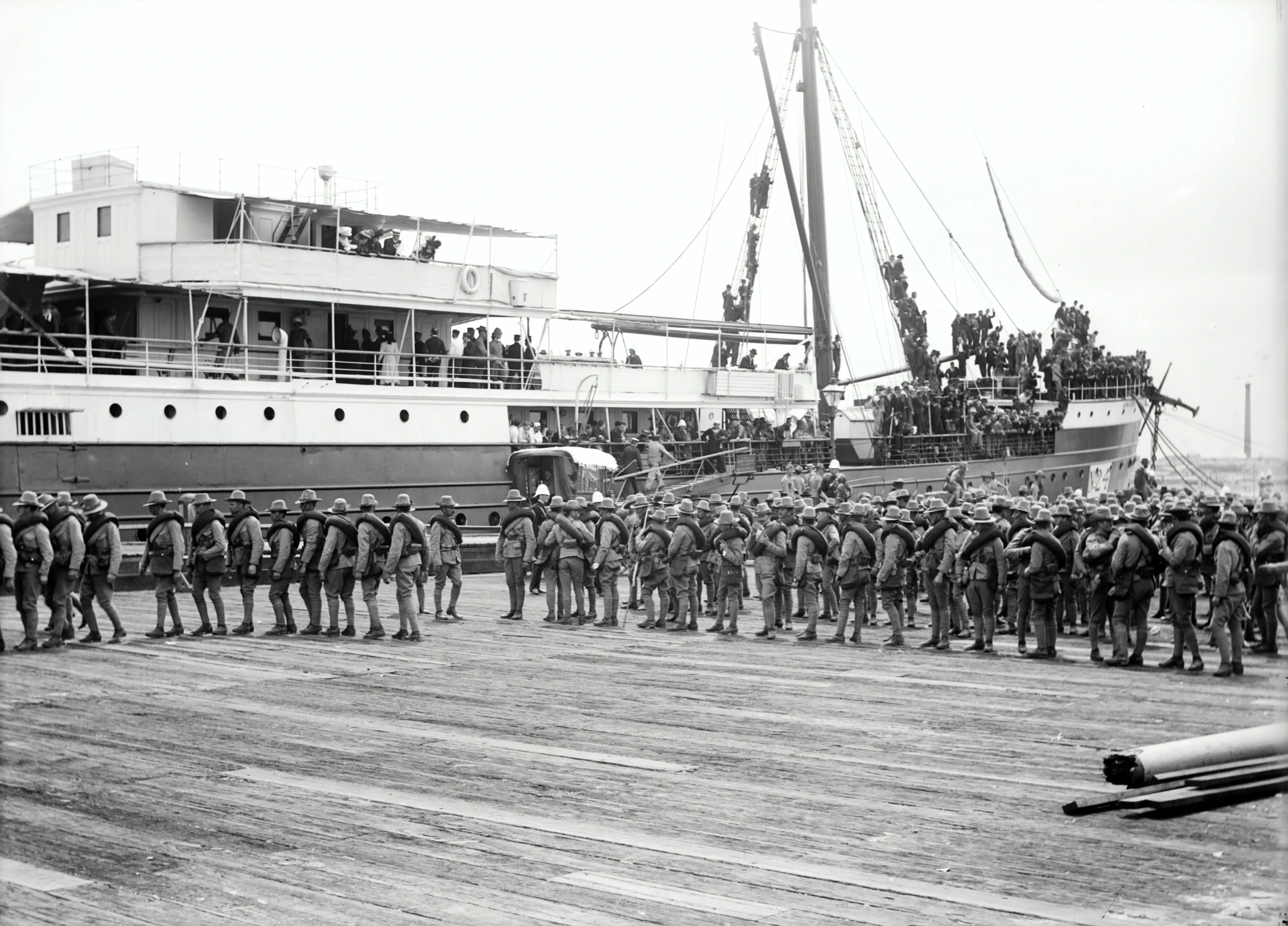 large group of men standing on a dock next to ships