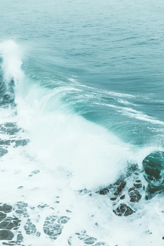 a wave hitting the ocean shore with a man surfing