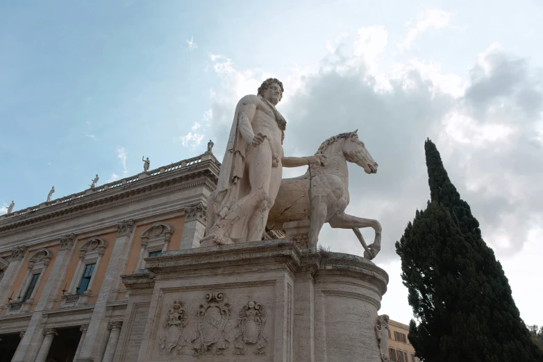 a statue of a man on a horse near an old building