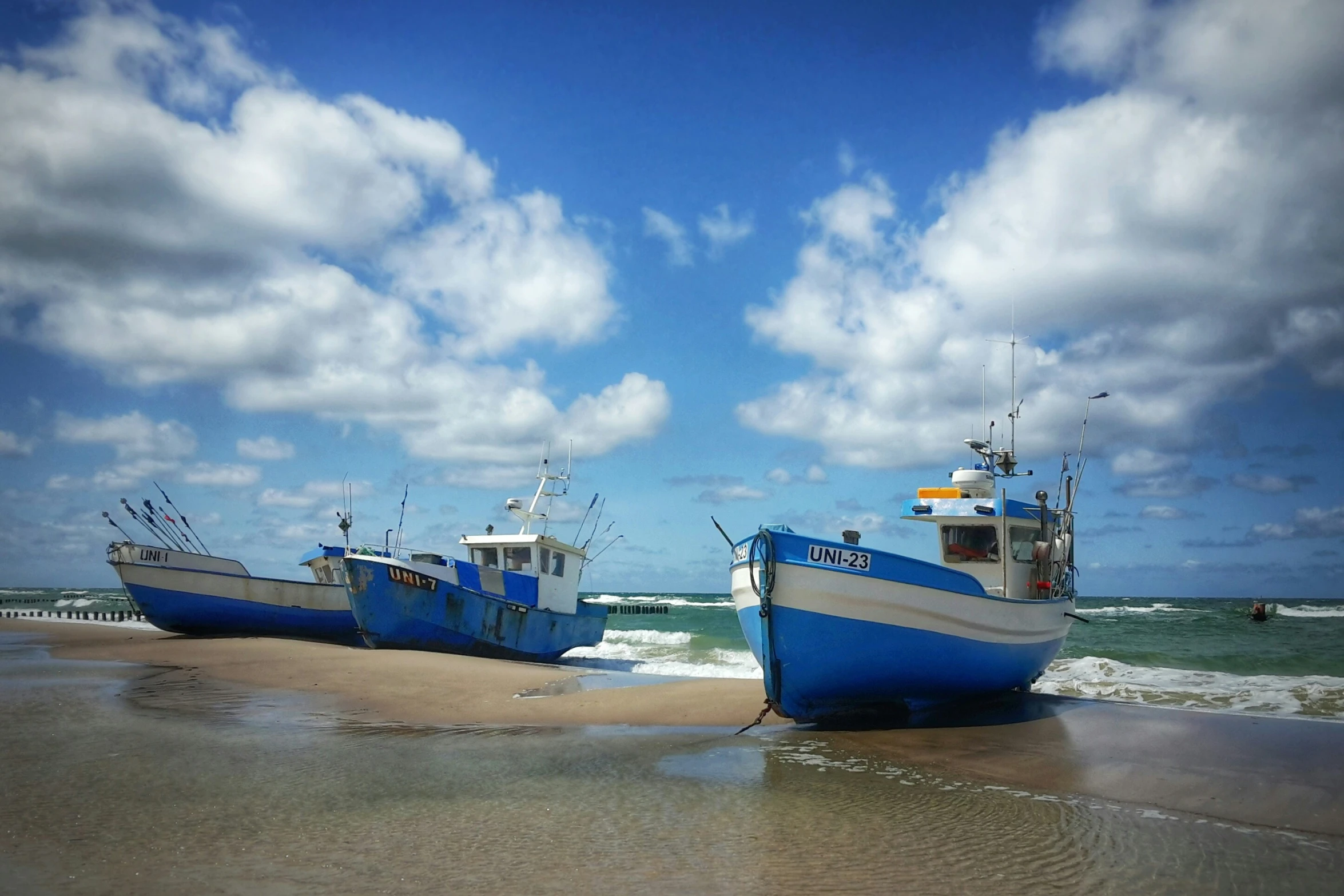 two small boats are sitting in the sand