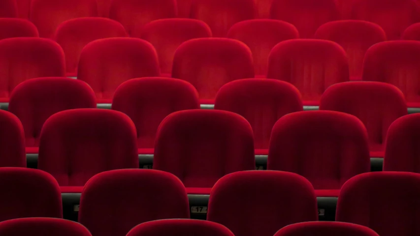rows of red velvet seats in a theater