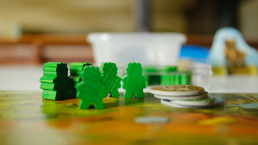 three green toy figures and a half dollar coin