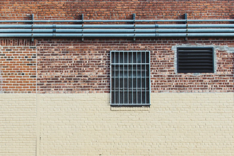 a yellow wall with bars and a door on it