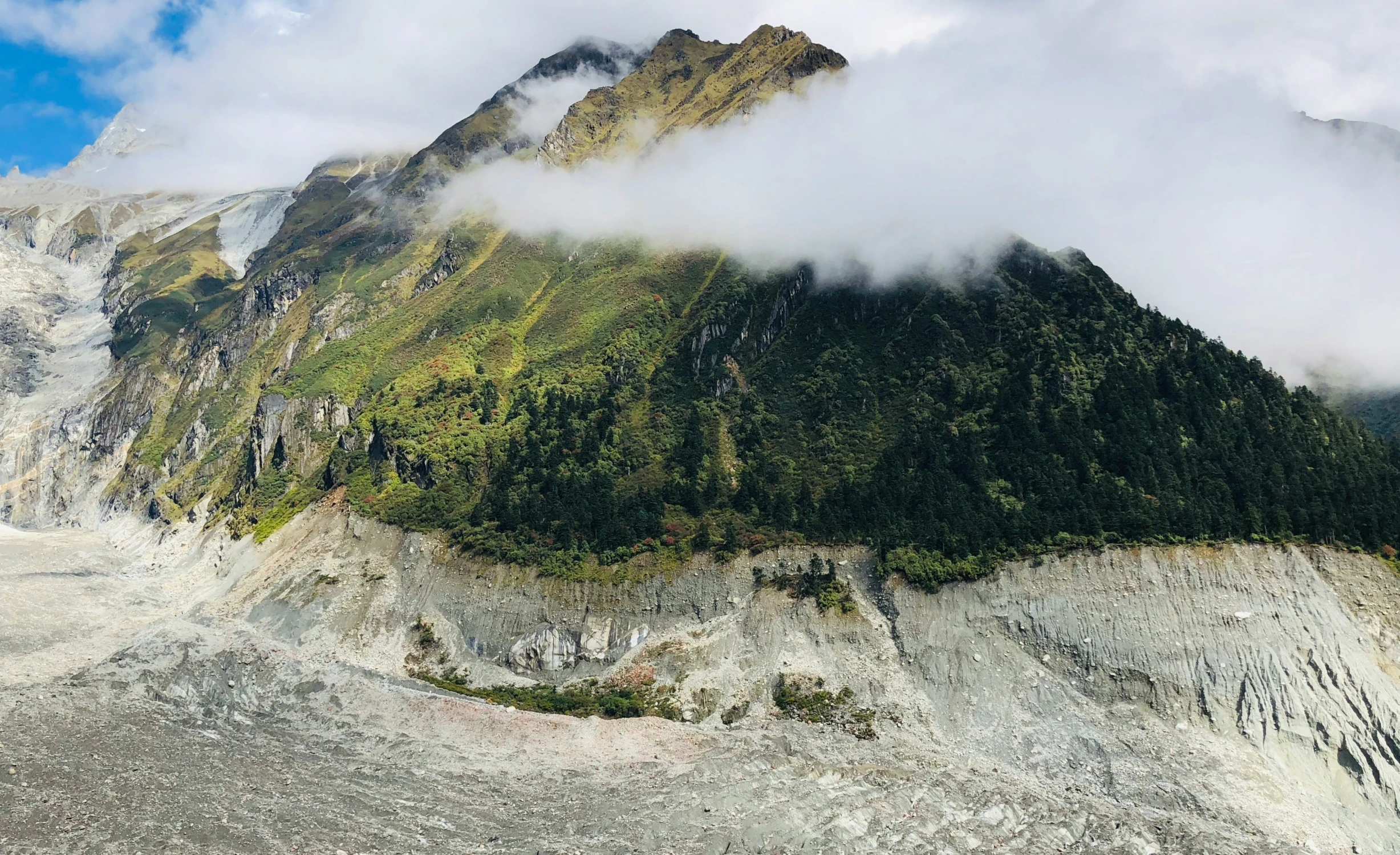 the clouds move in through the mountains on a sunny day