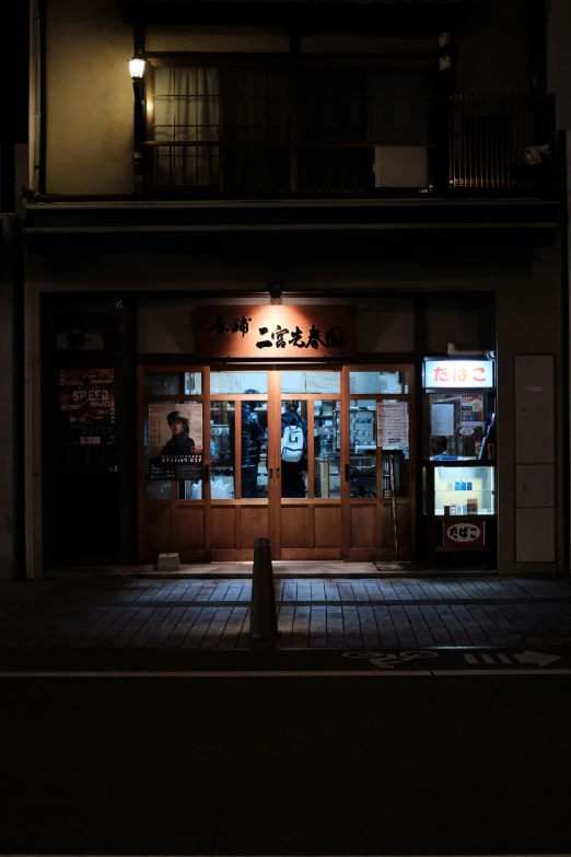 the dark image shows a building that has two windows with chinese characters