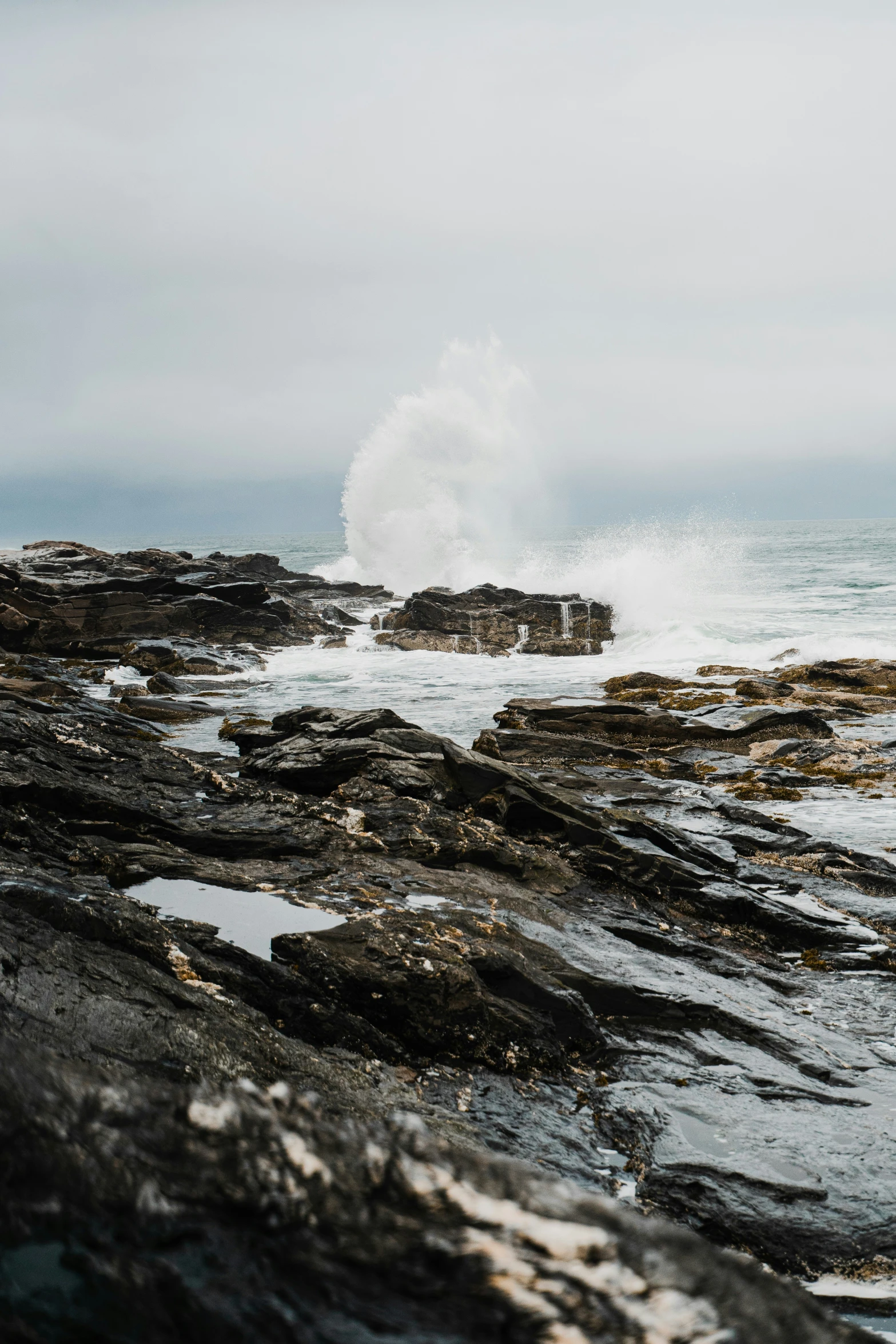 large wave breaking up on some rocks in the water