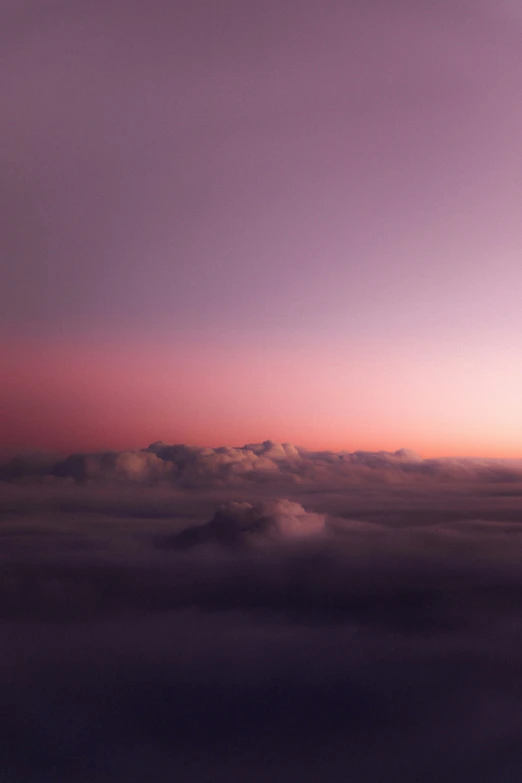 a view from the air over clouds at sunset