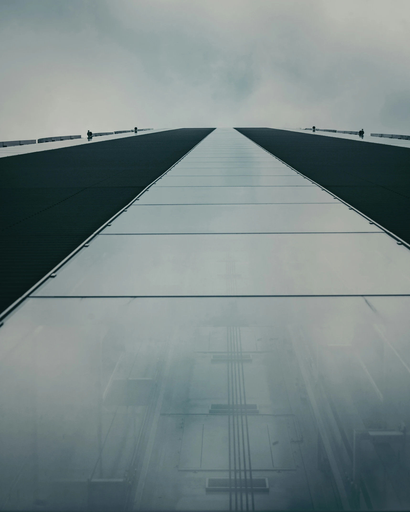 a long concrete bridge extending into the dark sky