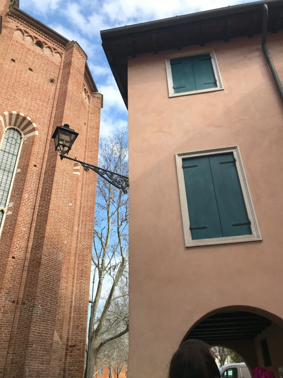 a large pink building has two windows with an opening at the entrance