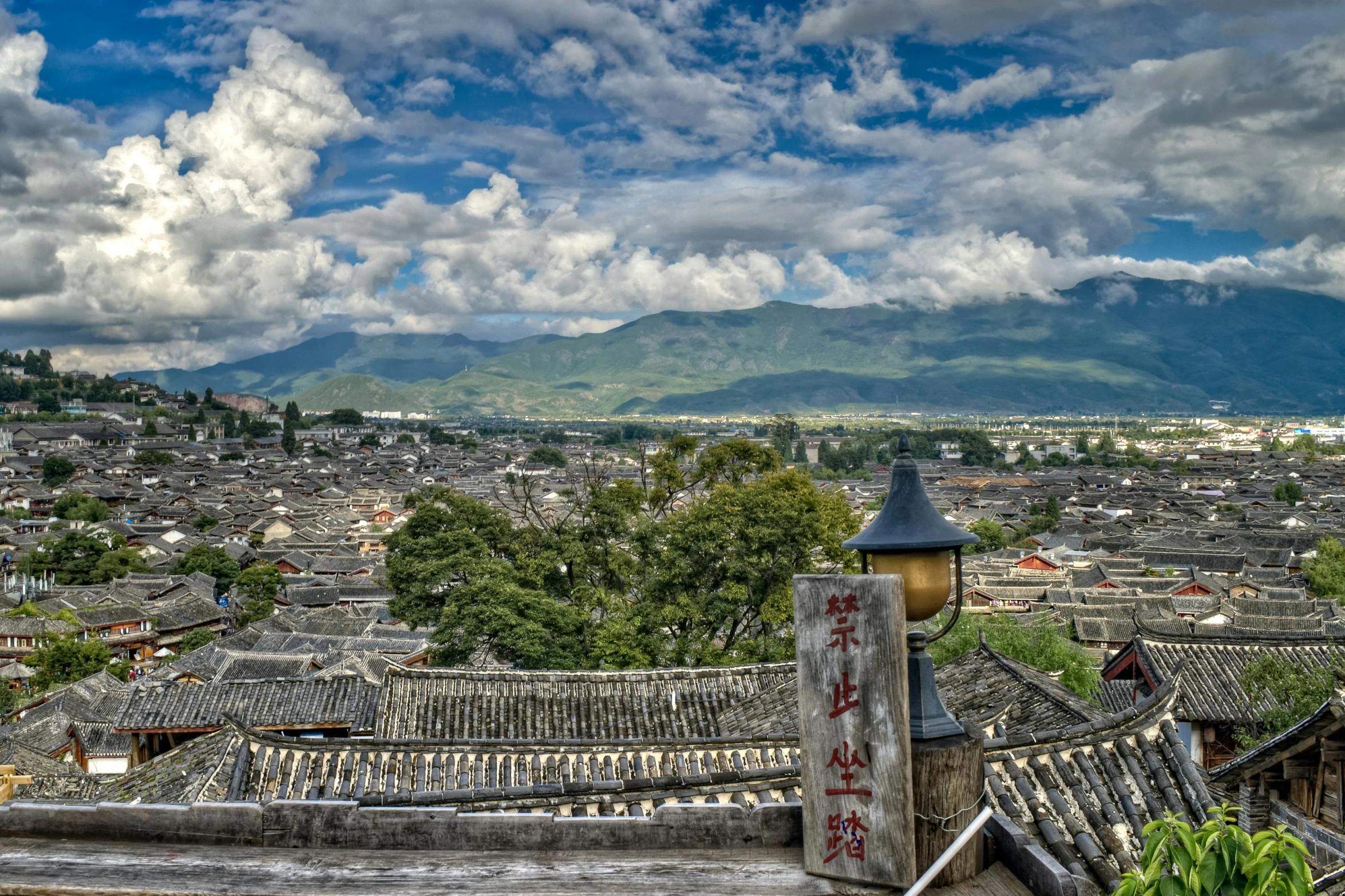 the mountain range in the distance near some roofs