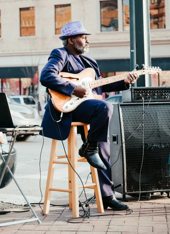 a man playing the guitar on a street corner