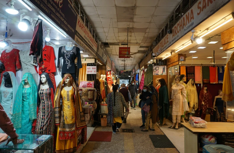 many people are shopping inside a market while some shoppers walk by